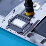 A screw being removed from a Surface Laptop 5