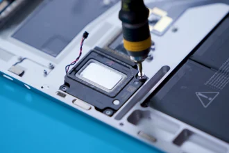 A screw being removed from a Surface Laptop 5