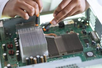 crop technician checking contacts on motherboard in workshop