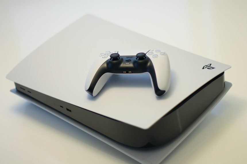 A PlayStation 5 with a DualSense controller laying on top.