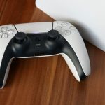 a white PlayStation 5 controller sitting on top of a white box