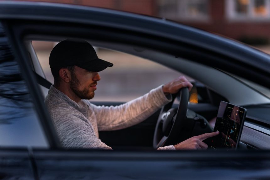 A man configuring something on a screen in his Tesla