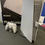 A PS5 and DualSense controller styled to look like a PS1