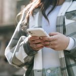 unrecognizable female in street with cellphone